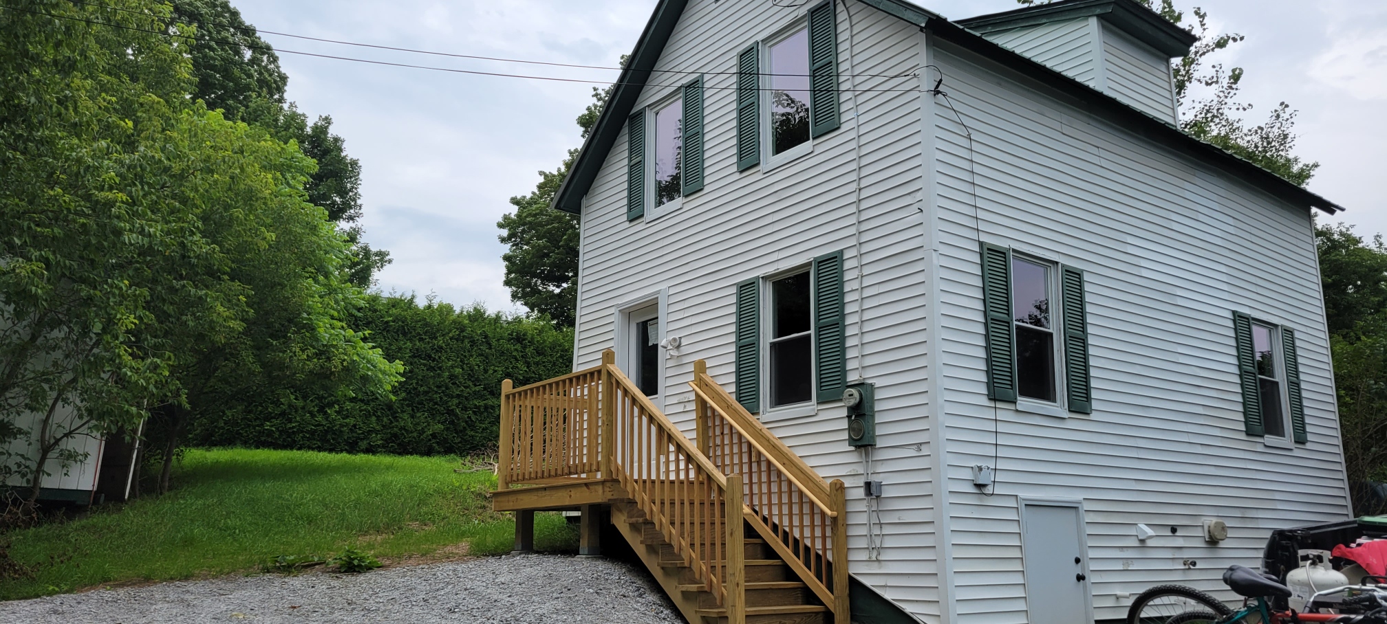 Image of a white Vermont home in a Green Field 